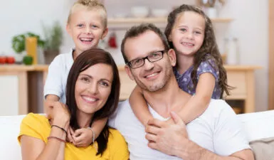 Photo de famille souriante évoquant les joies de la parentalité