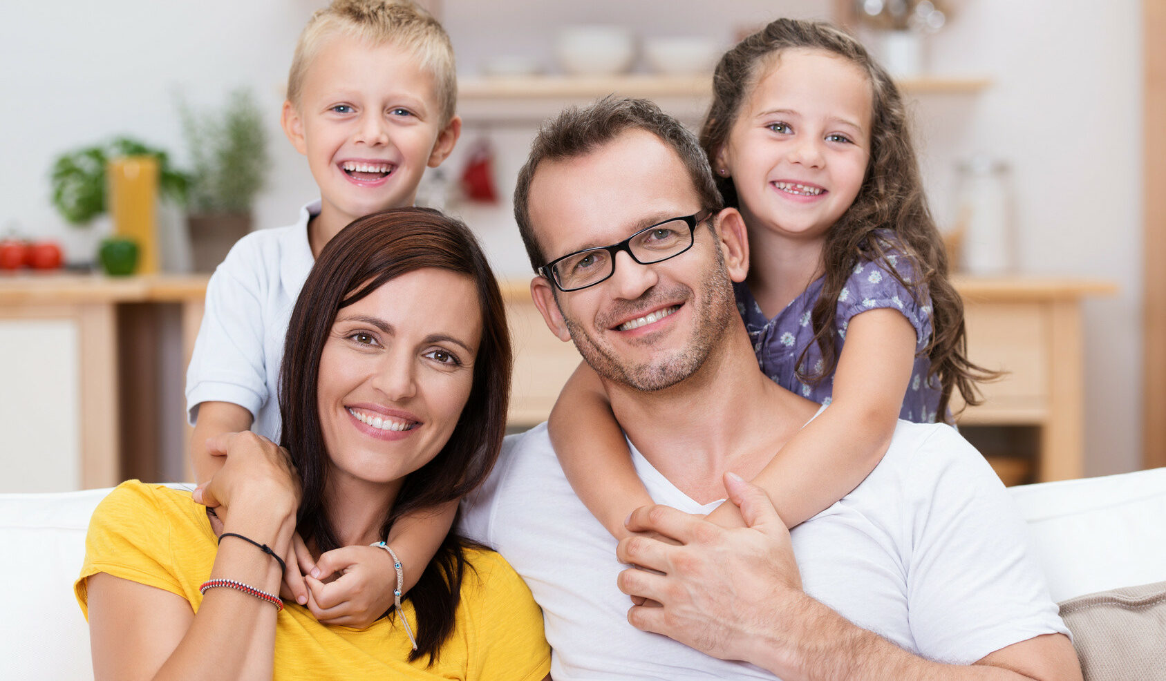 Photo de famille souriante évoquant les joies de la parentalité