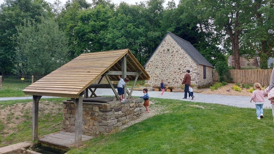 Des enfants s'amusent autour du puit de la motte féodale à Val d'Anast