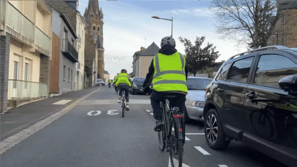Cyclistes circulant à vélo sur la rue de Guer en direction de l'église de Maure-de-Bretagne à Val d'Anast.