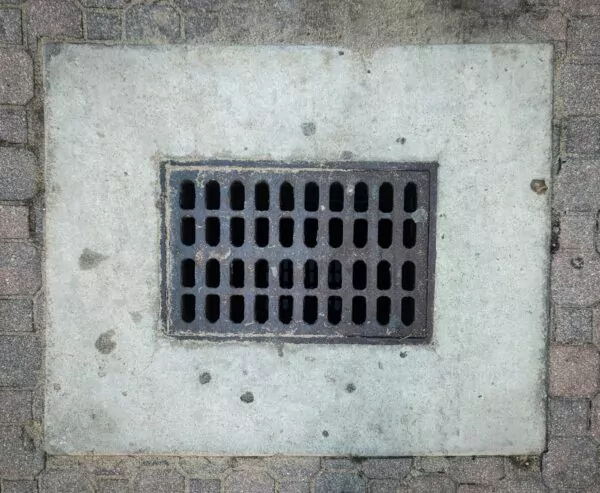Plaque d'égout : réseau d'assainissement collectif et non-collectif (SPANC) et gestion des eaux à Val d'Anast.